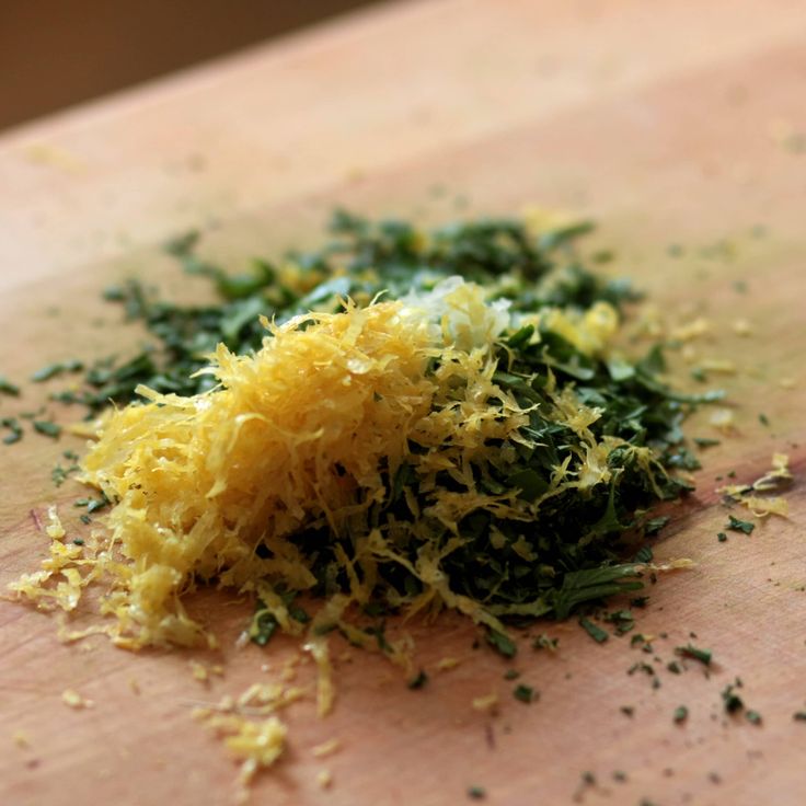 a wooden cutting board topped with yellow and green food scraps on top of it