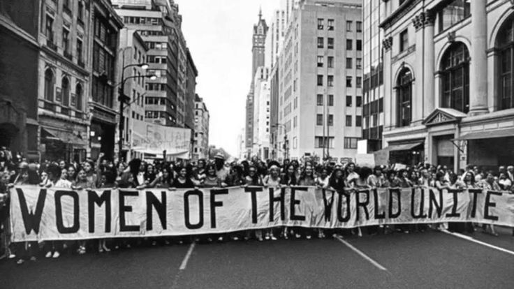 a crowd of people holding up a banner