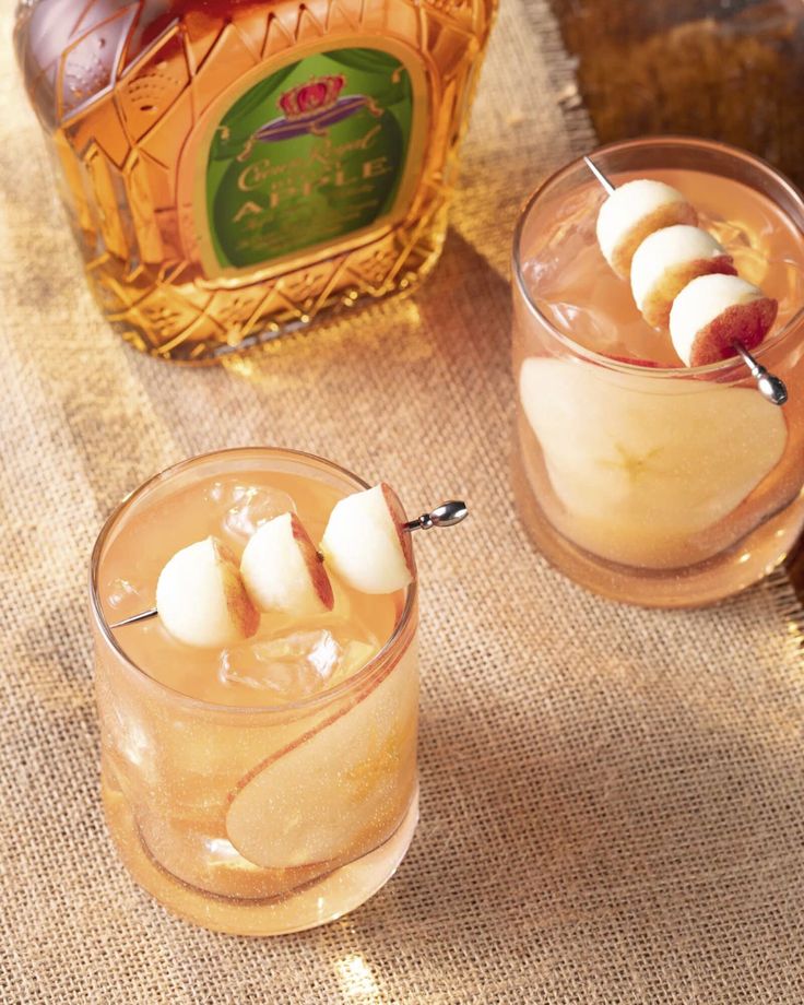 two glasses filled with drinks sitting on top of a table