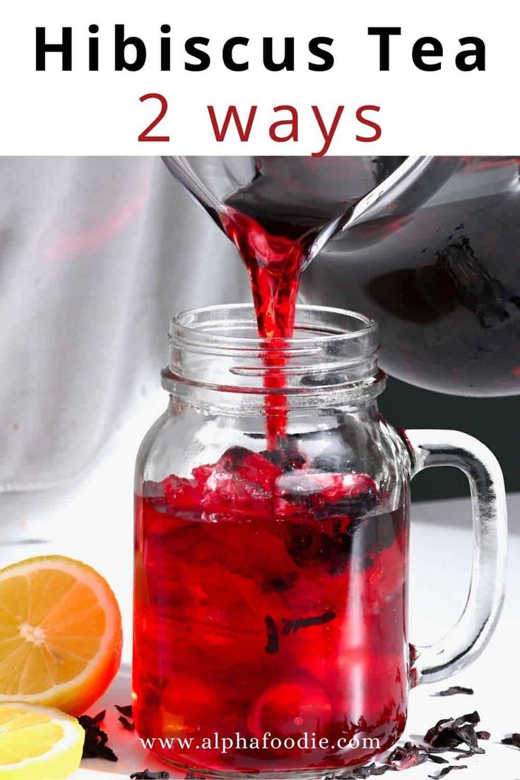 a person pouring red liquid into a mason jar filled with oranges and blackberries