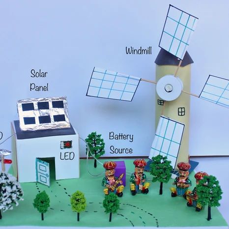 a paper model of a windmill and some small houses with solar panels on them,