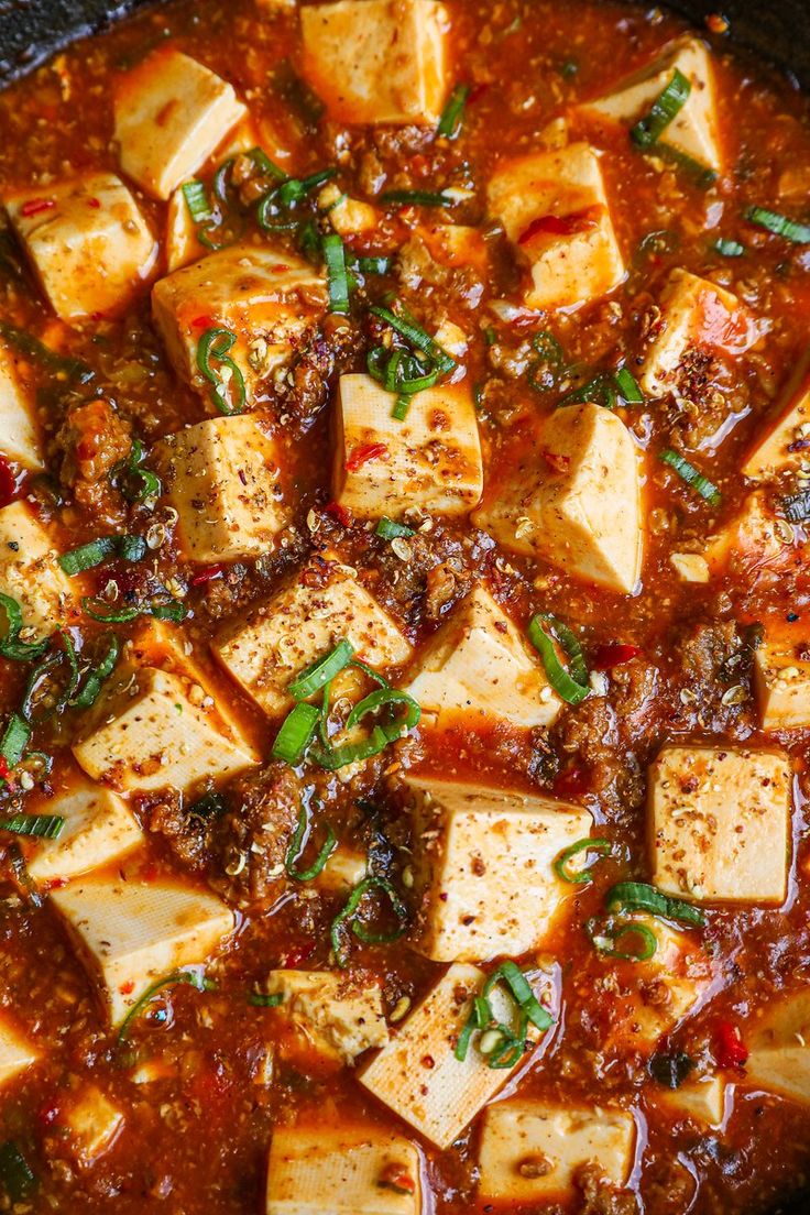 tofu and tomato soup in a black bowl