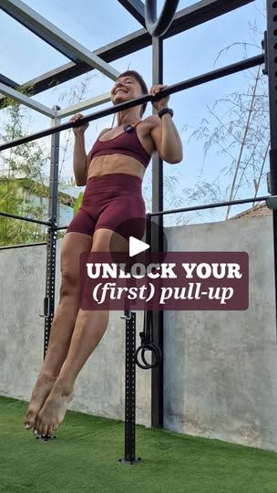 a woman is doing pull ups on a bar in the grass with text that reads unlock your first pull - up