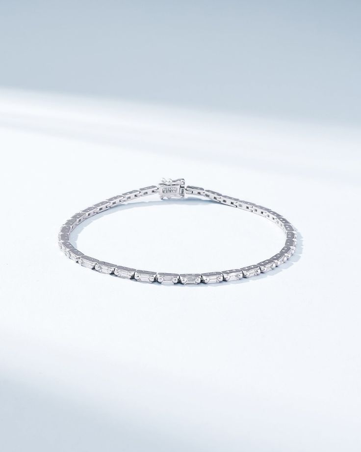 Crafted with 18-karat gold, this piece showcases baguette white diamonds in a horizontal design to maximize their brilliance with every movement. It is elegant and slender which offers versatility, making it a suitable and subtle addition to any outfit. Details 18k yellow gold, rose gold or white gold 1.75 carats of baguette white diamonds Bracelet measures 7" inches in length Box clasp with safety lock fastening 2mm width Ref: AKB574D Diamond White Platinum Bracelet With Baguette Diamonds, Platinum Diamond Bracelet With Baguette Diamonds In Diamond White, Luxury Platinum Diamond Bracelet With Baguette Diamonds, Timeless Diamond Bracelet With Baguette Cut Accents, Luxury Diamond Bracelet With Baguette Cut Single Diamonds, White Gold Diamond Bracelet With Baguette Cut, Luxury Baguette Cut Diamond Bracelet With Single Cut Diamonds, Fine Jewelry Diamond Bracelet With Baguette Cut, White Gold Baguette Cut Diamond Bracelet