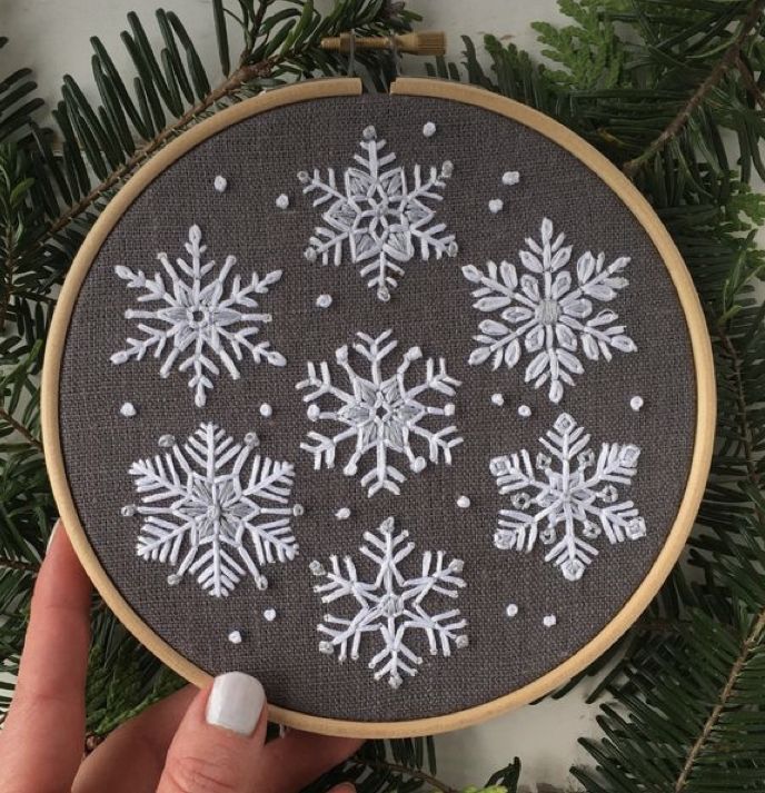 someone is holding up a cross stitch snowflake ornament