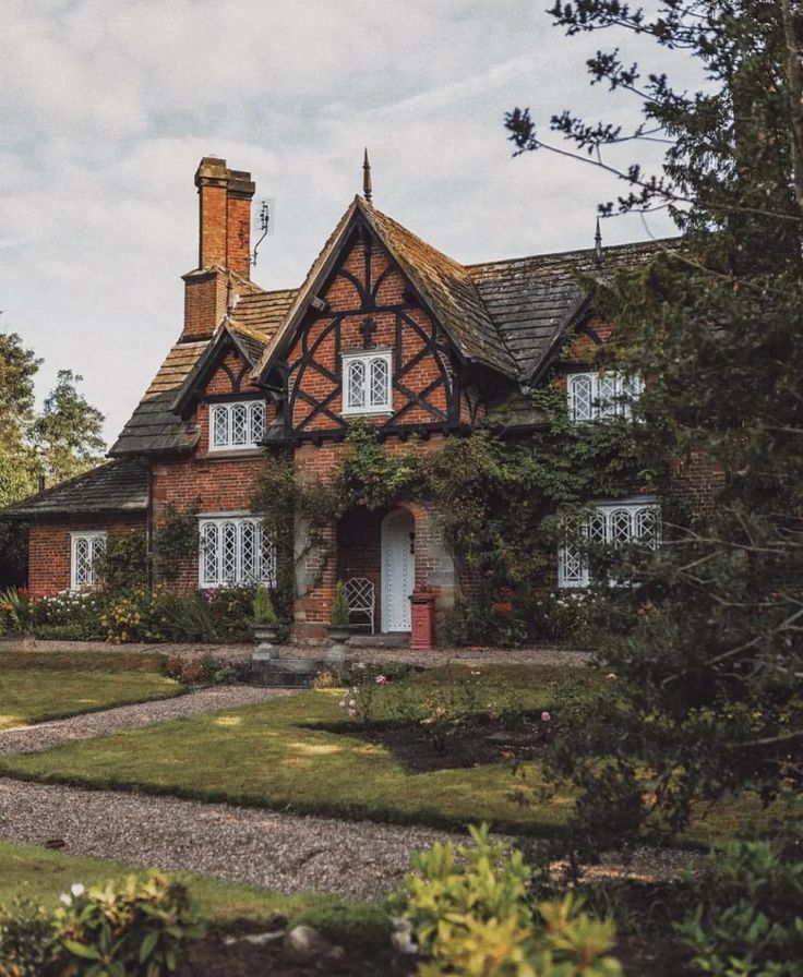 an old brick house surrounded by greenery and trees