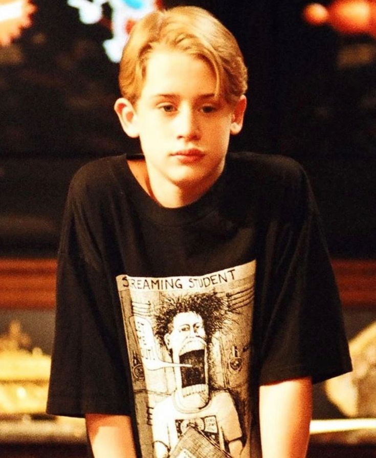 a young boy sitting on top of a wooden table with a skateboard in front of him