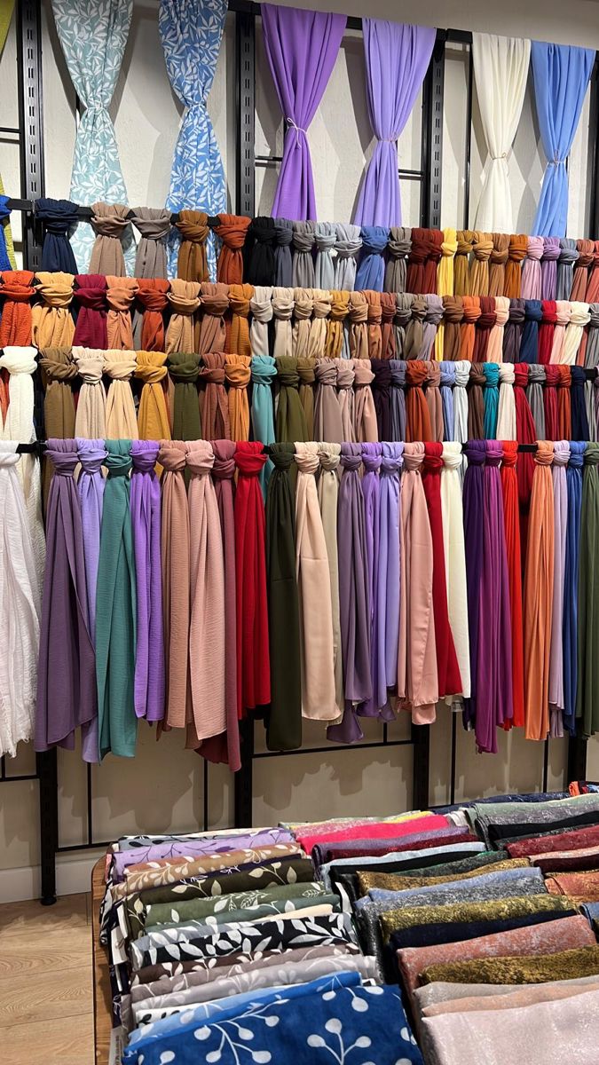 many different colored scarves are on display