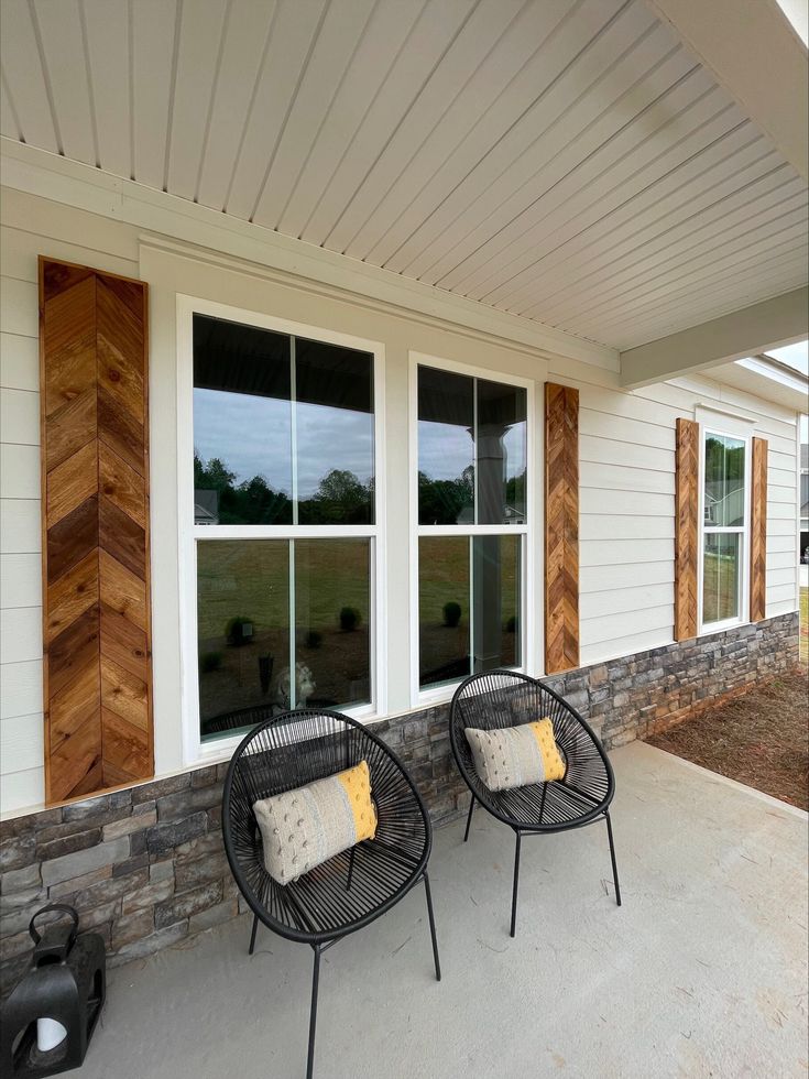 two chairs sitting on the front porch of a house