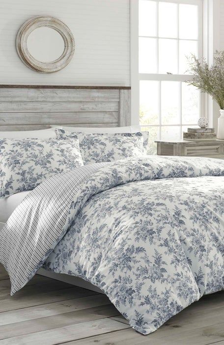 a bed with blue and white comforters in a room