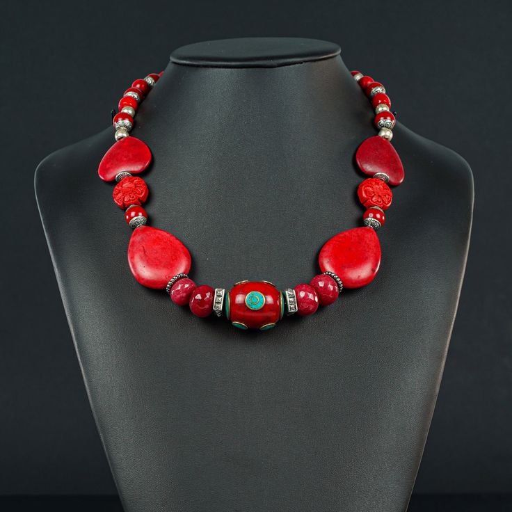 This unusual red Necklace is 20 1/4" long made with a Tibetan oval centerpiece of Enamel and Turquoise (30x20mm) framed with 4 faceted red Jade rondels, red  Howlite ovals and hearts and Tibetan red , silver ended 9mm decorative beads to frame the Sterling lobster clasp (10x20mm) Red Coral Necklaces As Gifts, Handmade Oval Beads Red Coral Jewelry, Handmade Red Coral Oval Beads Jewelry, Handmade Red Coral Jewelry With Oval Beads, Red Polished Beads Round Jewelry, Red Coral Jewelry With Natural Stones, Red Gemstone Necklace For Valentine's Day, Handmade Red Oval Necklace, Handmade Red Necklaces For Valentine's Day