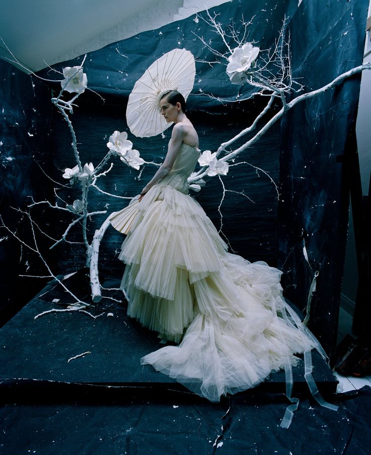 a woman in a white dress holding an umbrella