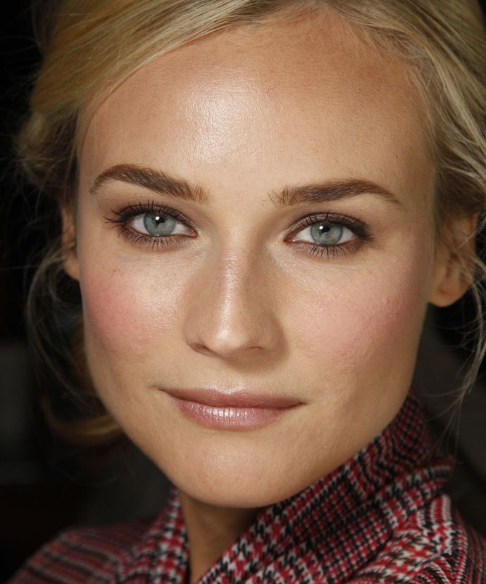 a woman with blonde hair and blue eyes wearing a red checkered shirt looking at the camera