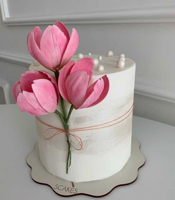 there is a white cake with pink flowers on it