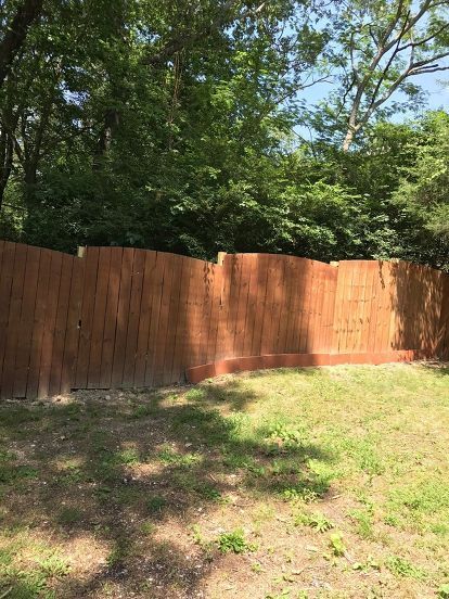 a wooden fence in the middle of a yard