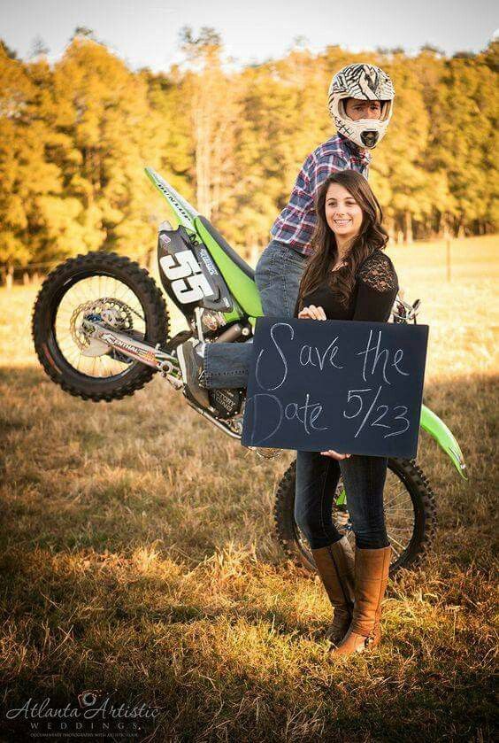 a man and woman holding a sign that says save the date on a dirt bike