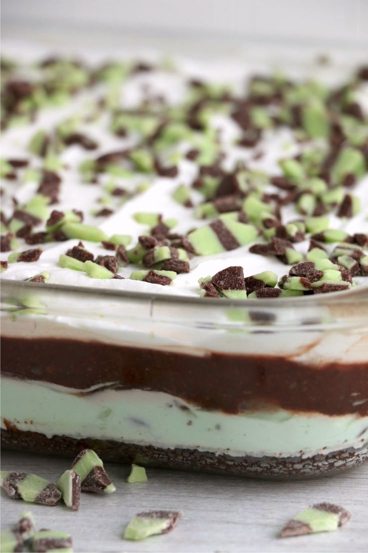 a dessert dish with chocolate and white frosting on the top, topped with mint sprinkles