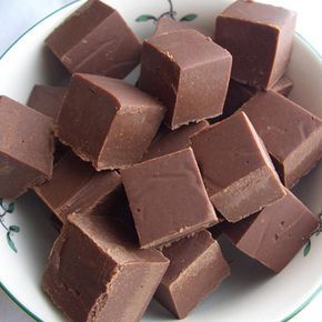 a white bowl filled with chocolate pieces on top of a green and white table cloth