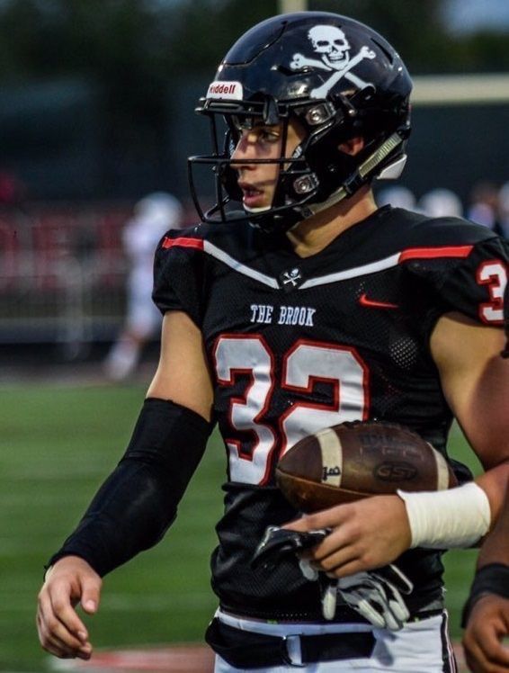 a football player holding a ball on top of a field