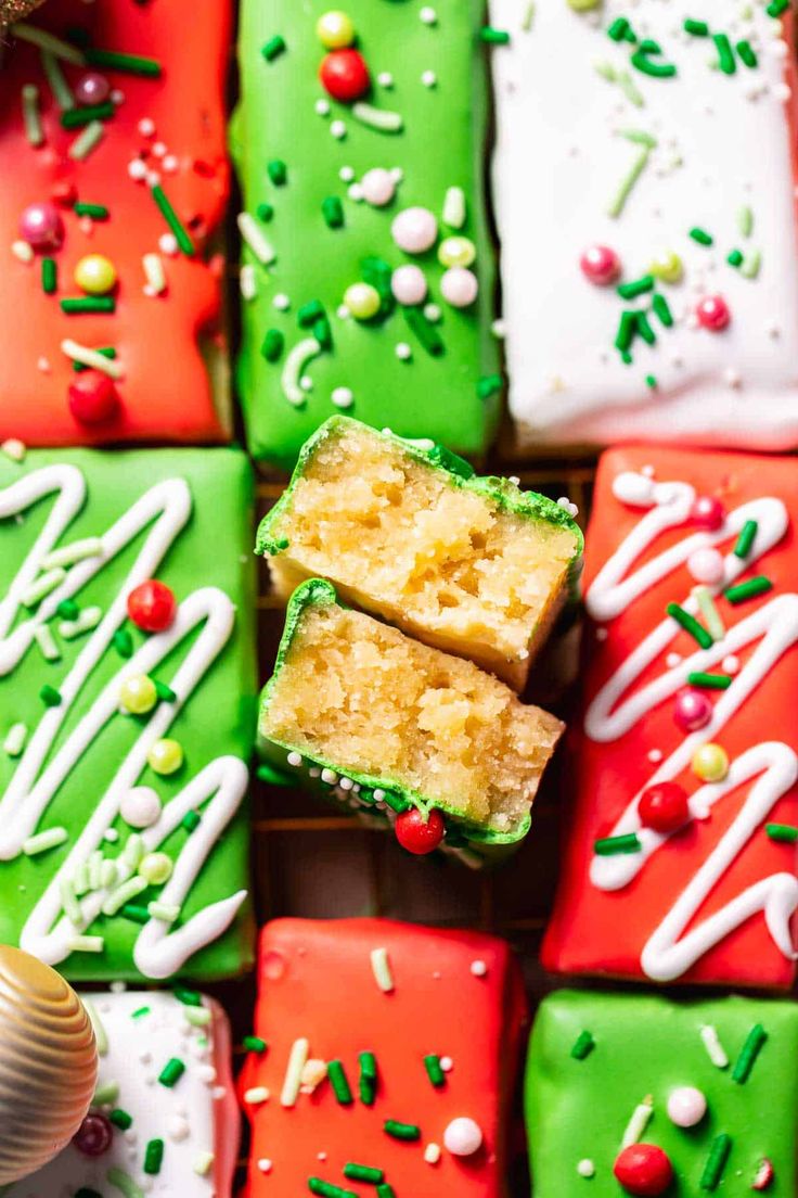 many different colored desserts with white frosting and sprinkles on them