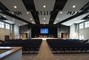 an empty auditorium with rows of chairs and a projector screen