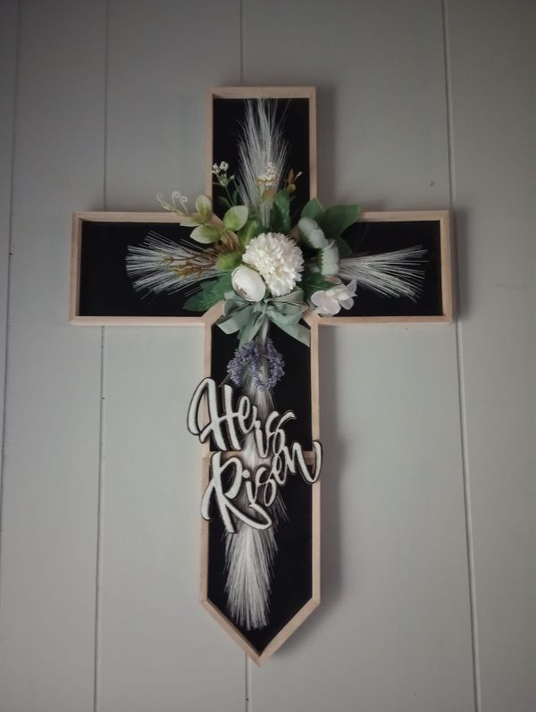 a cross decorated with flowers and feathers on the wall next to a sign that says altar rock