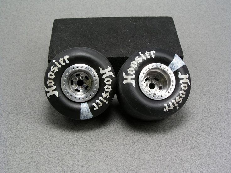 two black wheels with white lettering on them sitting on a gray counter top next to each other