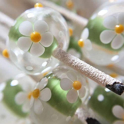 some glass balls with flowers on them and a stick sticking out of the top one