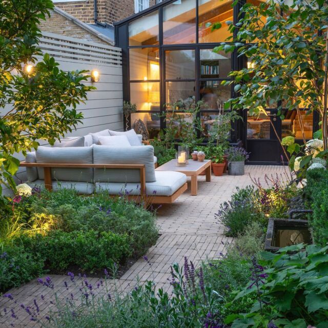 an outdoor living area with couches and plants