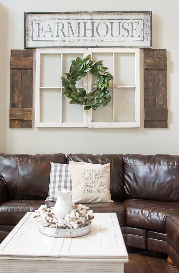 a living room with leather couches and a coffee table in front of a window