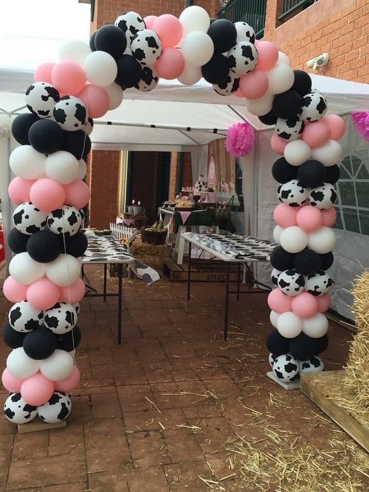 a balloon arch decorated with black and white balloons