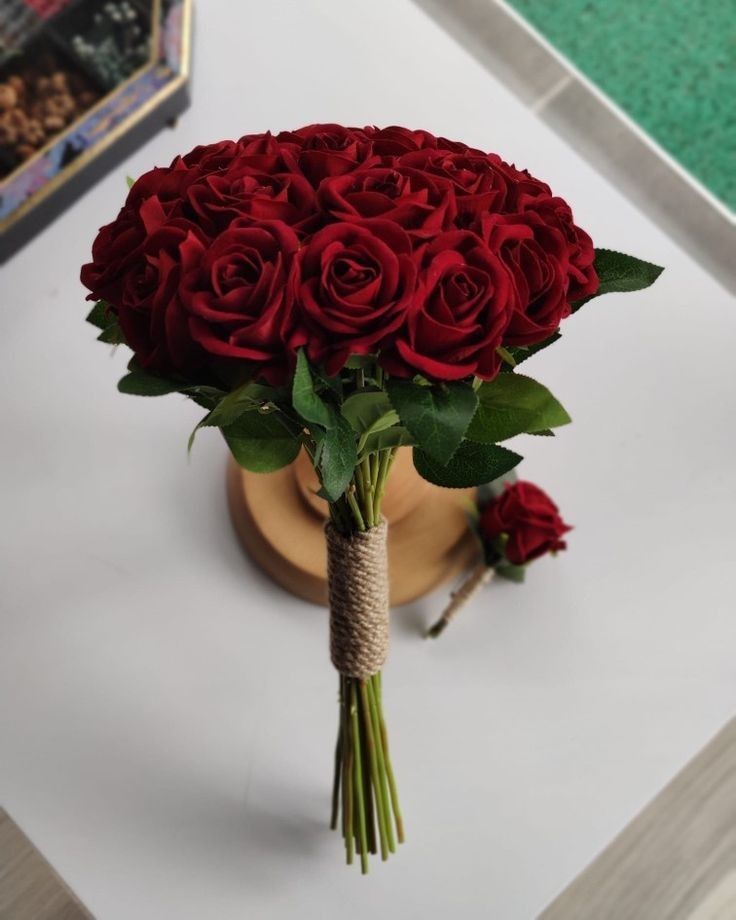 a bouquet of red roses sitting on top of a table