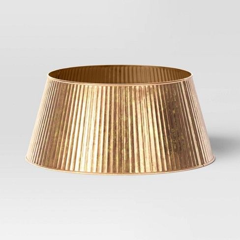 a gold pleated lamp shade on a white background