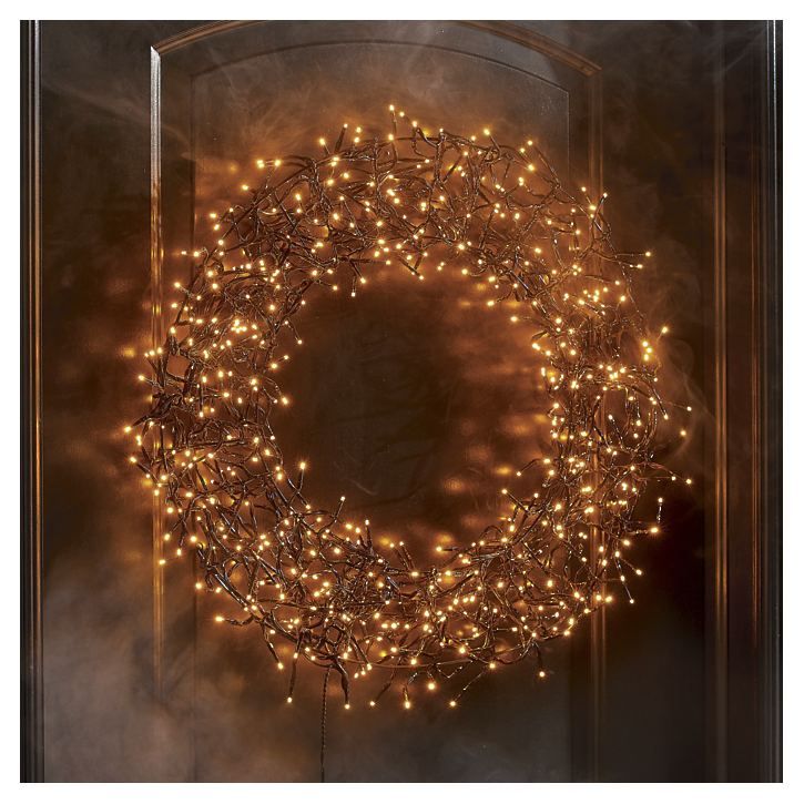 a lighted wreath is shown in front of a door