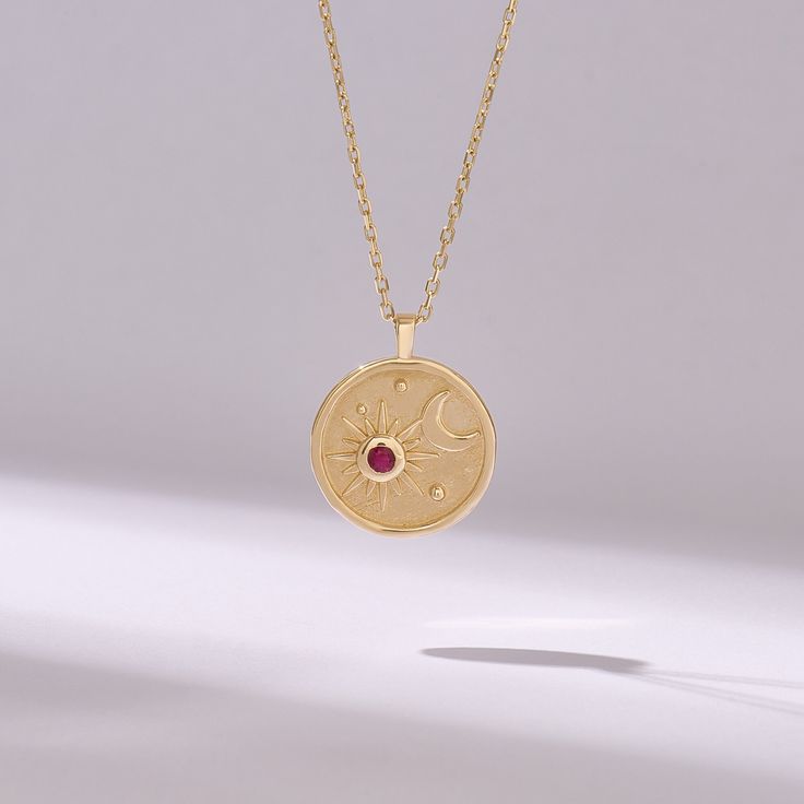 Introducing our Ruby Moon & Star Circle Charm Necklace, a celestial-inspired piece handcrafted with exquisite detail and elegance. Crafted from 14k solid yellow gold, this pendant features a captivating moon and star design encircling a genuine pink ruby birthstone disc, adding a touch of celestial beauty to your ensemble. The radiant pink ruby symbolizes love, passion, and vitality, making it the perfect birthstone for those born in July or anyone who appreciates its vibrant hue. 𝐈𝐭𝐞𝐦 𝐃𝐞? Celestial Yellow Gold Jewelry With Moon Phase, Celestial 14k Gold Medallion Jewelry, Celestial 14k Gold Birthstone Jewelry, Celestial Style 14k Gold Birthstone Jewelry, Celestial Pendant Jewelry That Is Tarnish Resistant, Celestial Round Pendant Jewelry With Tarnish Resistance, Celestial Pendant Jewelry, Tarnish Resistant, Celestial Jewelry With Tarnish Resistant Round Pendant, Celestial Round Pendant Jewelry Tarnish Resistant