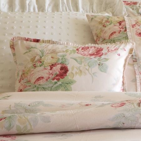 a bed with flowers and polka dots on the comforter, pillows and pillow cases