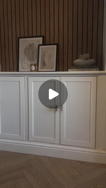 a white entertainment center with two pictures on the top and bottom cabinets in front of it