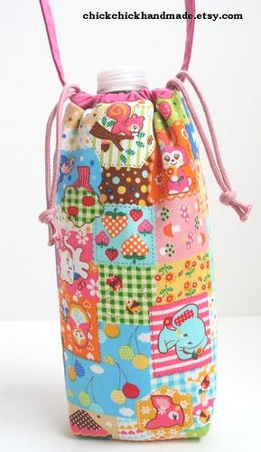 a small colorful bag with pink handles on the front and bottom, decorated with patchwork fabric