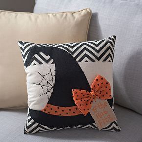 a black and white pillow sitting on top of a couch next to a gray sofa