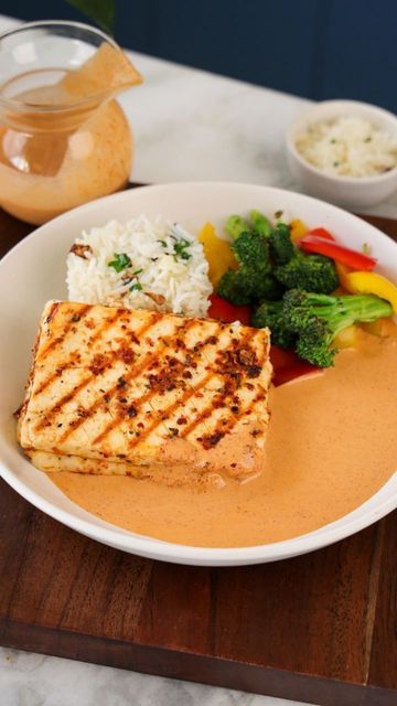 a white plate topped with meat and veggies on top of a wooden table