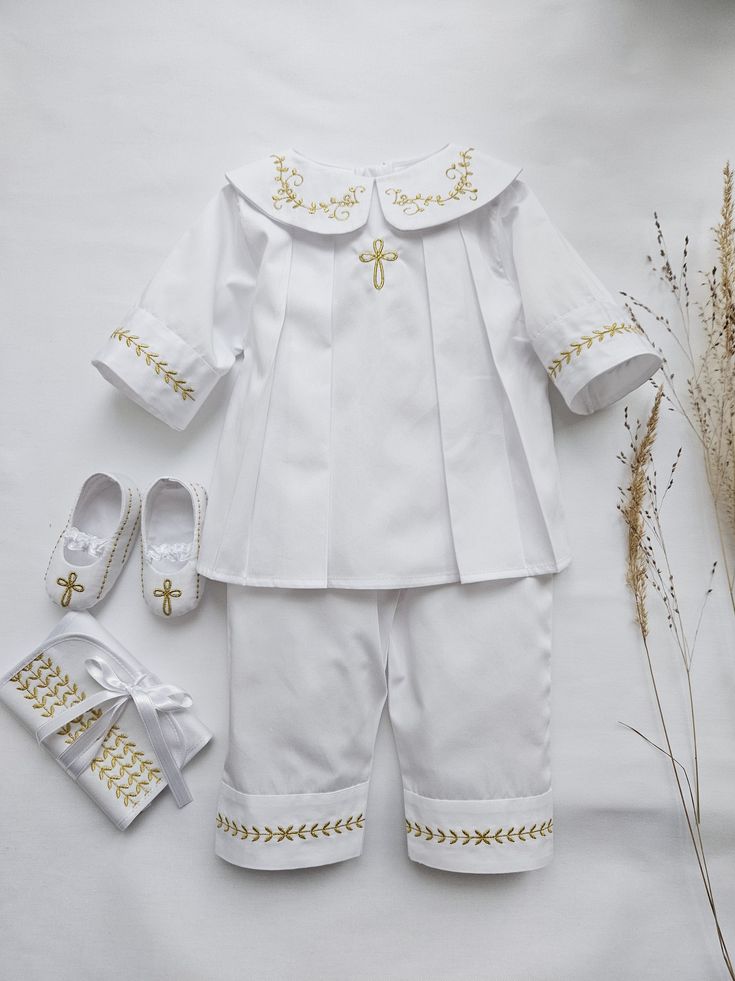 "Lovely Baptism outfit set for a Baby Boy made from soft pure polished cotton.  It looks nice and glitters elegantly. Christening Outfit Set, color white, decorated with gold embroidery.  Embroidery of Cross or JHS, as well as a kind of Cross, could be changed upon request.  The thread color of the embroidery could be: gold, silver, white, ivory, blue Booties, hat, blanket, hair bag, bib could be included in the SET option.  Personalization is available on each item.  If the christening will tak White Cotton Baptism Sets, White Cotton Sets For Baptism, Cotton Baptism Sets, Fitted Embroidered Sets For Baptism, White Embroidered Baptism Sets, White Embroidered Sets For Baptism, Embroidered Cotton Sets For Baptism, Cotton Embroidered Sets For Baptism, Elegant Embroidered Baptism Sets