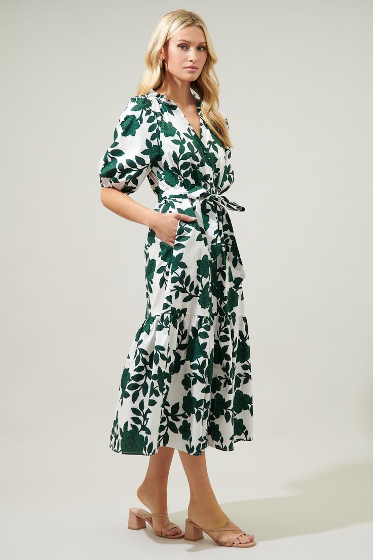 Step out in an evergreen, floral state of mind. Sweet, green floral motifs sit against a cool and crisp, white-ground to shape the Wynette Dress. A shift maxi with bubble sleeves that frame a functional button front dress. It maintains a sheath silhouette, with a sash style belt to add shape.The buttons end where they meet a bottom tier split.- Breathable - Belted- Button front- Pockets- Color: White ForestSize + Fit - Model is 5'8" and wearing size XS- Measurements taken from size S - Chest: 19 Spring Business Casual, Mock Neck Blouse, Button Front Dress, Tiered Midi Dress, Midi Length Skirts, Head Over Heels, White Midi Dress, State Of Mind, Floral Motifs