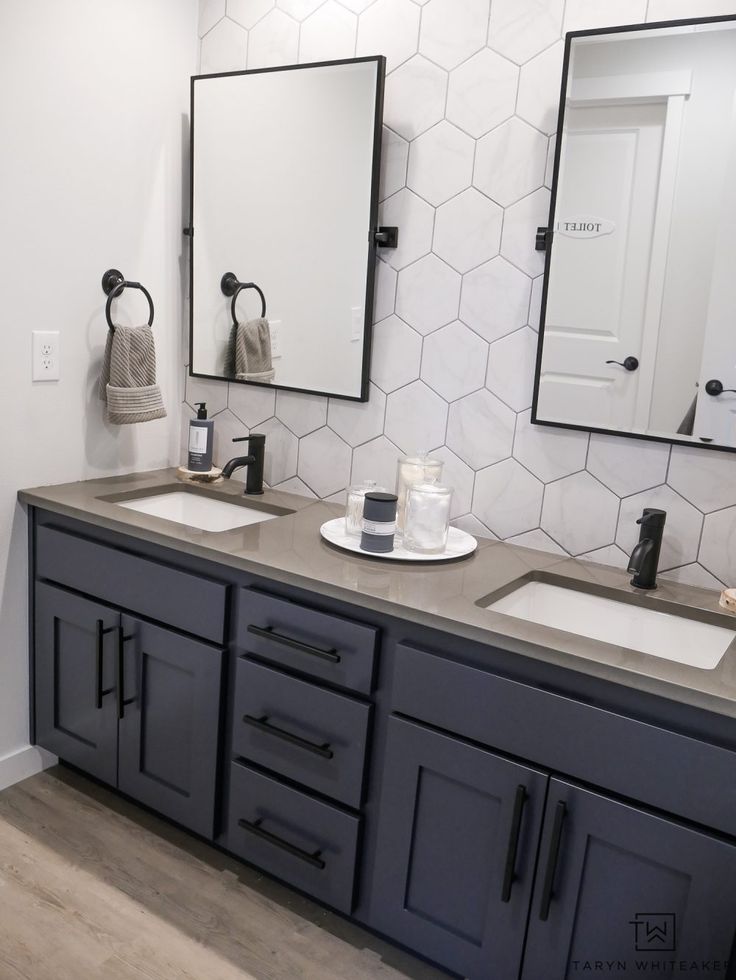 a bathroom with two sinks and mirrors on the wall