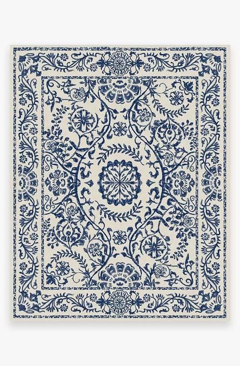 a blue and white rug with an intricate design on the bottom, in front of a white background