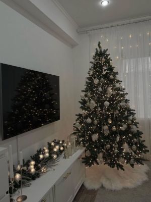 a living room with a christmas tree in the corner and other decorations on the wall