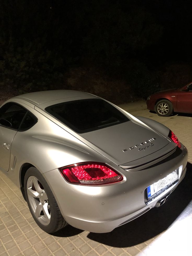 a silver sports car parked on the street at night