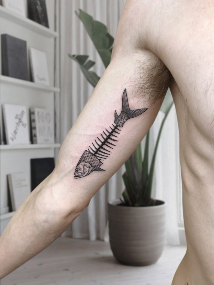 a man's arm with a fish tattoo on the left side of his body