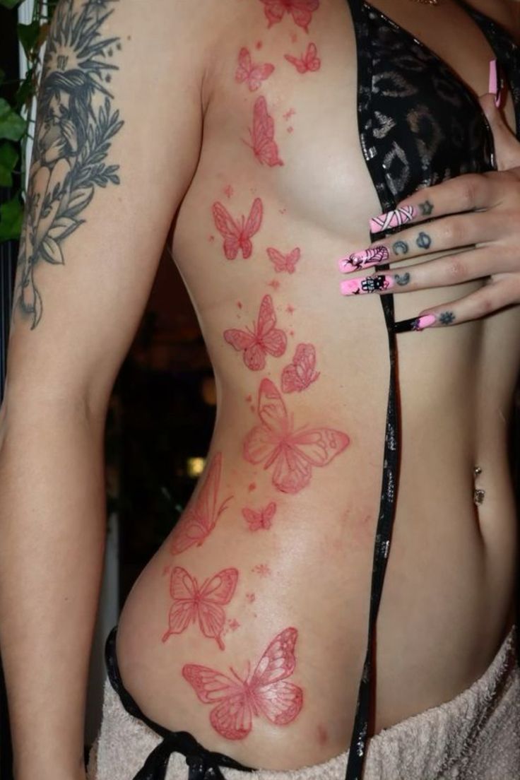 a woman with butterfly tattoos on her back and chest is holding a cell phone in her hand