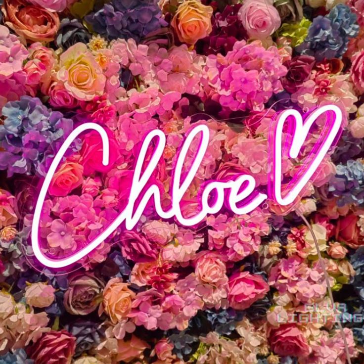 the word cloo written in pink neon light surrounded by colorful flowers and greenery