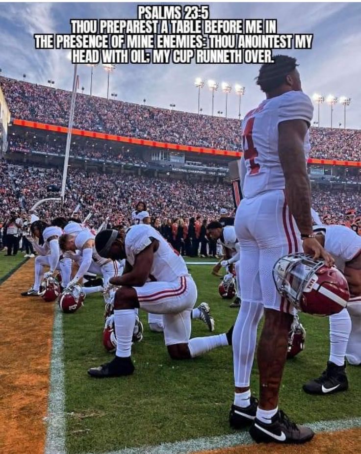 two football players kneel down on the field